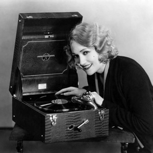 78 RPM Edwina Booth plays a record on her nifty portable record player 1930s